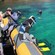 Guests in snorkel gear entering the water from an inflatable boat